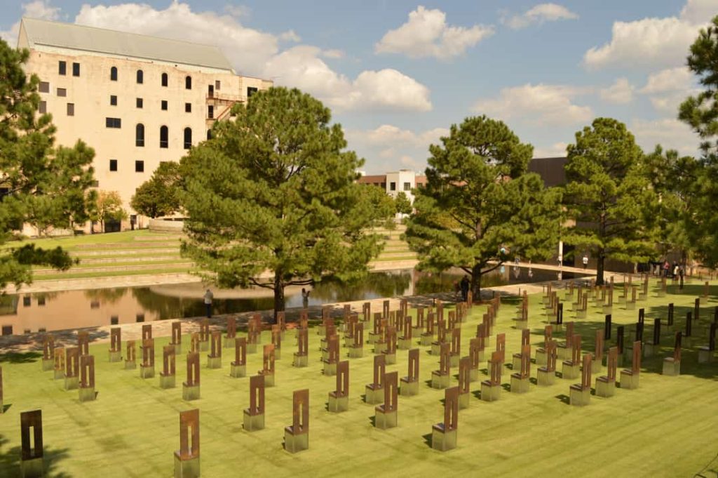 Breed uitzicht over het stoelenveld van het Oklahoma City National Memorial met bomen en een reflecterende vijver