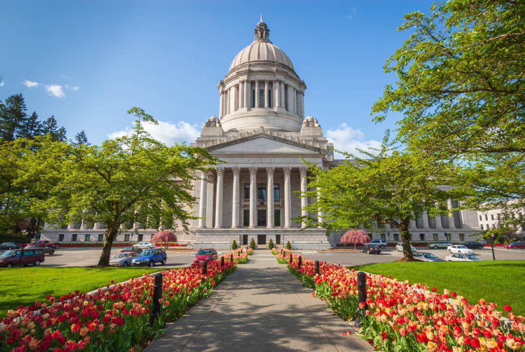 Koepelgebouw van het Washington State Capitol in Olympia met rijen bloeiende rode en gele tulpen langs het pad ervoor