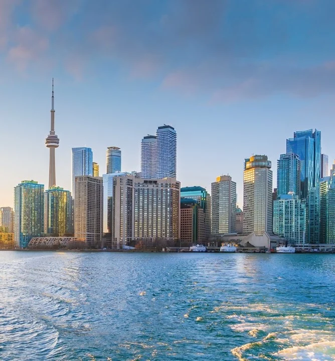 Wolkenkrabbers en de CN Tower langs het water van Toronto, gezien vanaf een boot met schuimend kielzog op de voorgrond