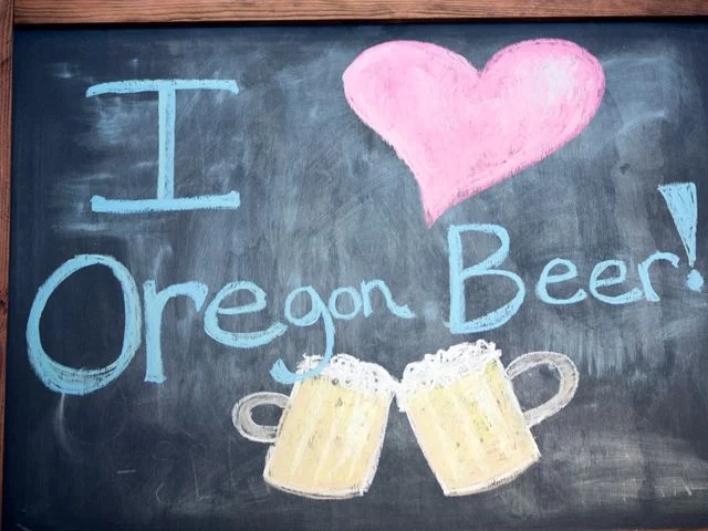 Handbeschilderd krijtbord met een roze hart en twee schuimende bierpullen en de tekst I love Oregon Beer