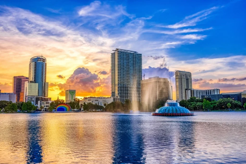 De skyline van Orlando met een fontein in Lake Eola weerspiegelt in het water tijdens een kleurrijke zonsondergang