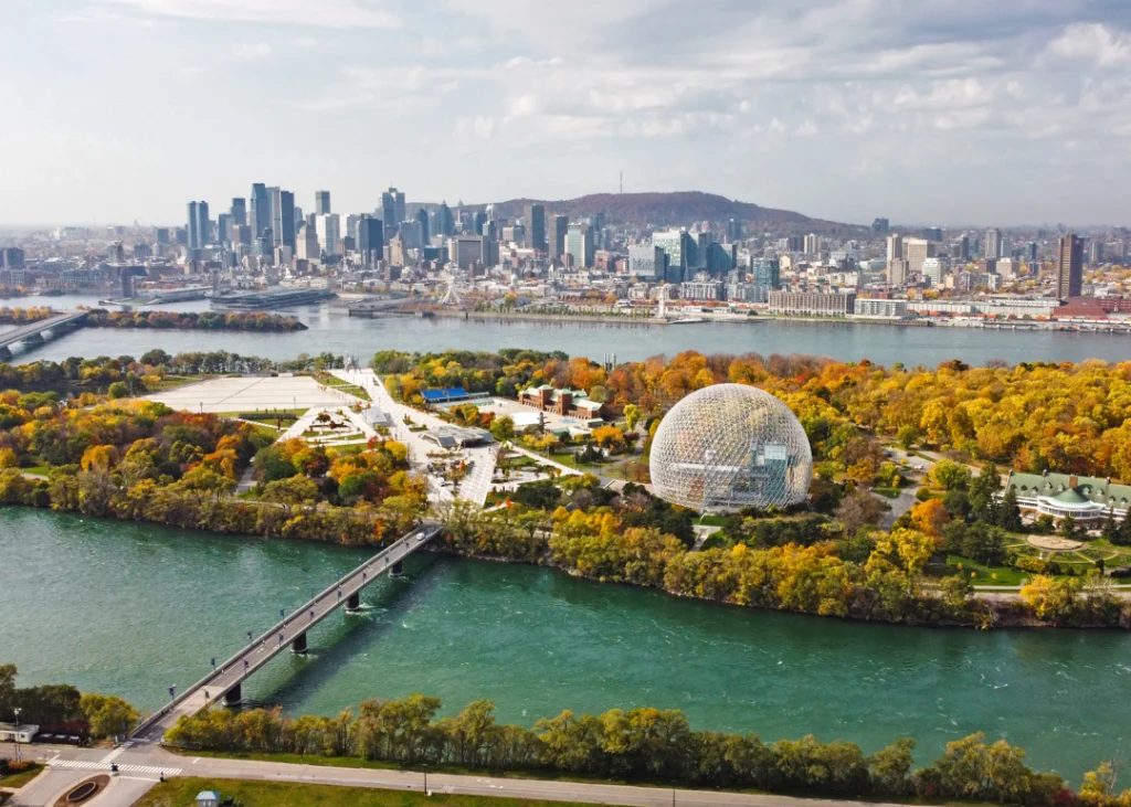 De groene torenspitsen van het Canadese parlementsgebouw steken boven de bomen uit langs de oever van de rivier in Ottawa