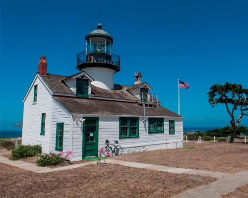 Witte vuurtoren met groene koepel en Amerikaanse vlag bij de Point Pinos vuurtoren in Pacific Grove