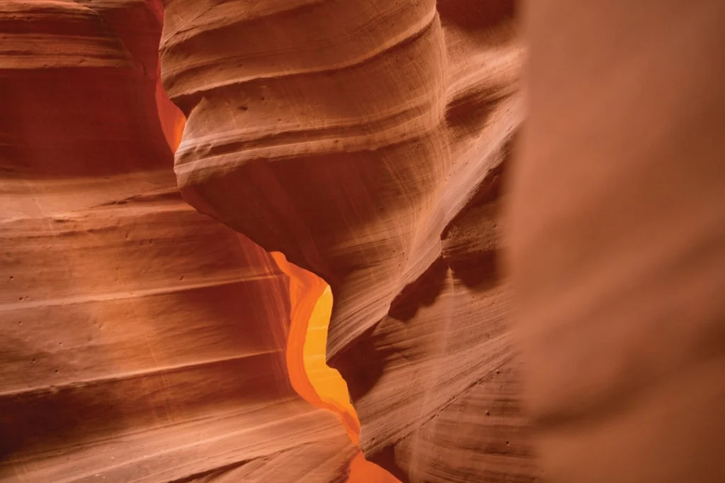 Gladde golvende roodoranje zandstenen wanden van een slotcanyon met een lichtstreep bij Antelope Canyon