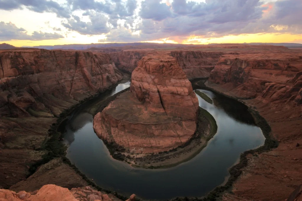 Panoramisch uitzicht vanaf de rand over de hoefijzervormige bocht van de Colorado River bij Horseshoe Bend bij zonsondergang