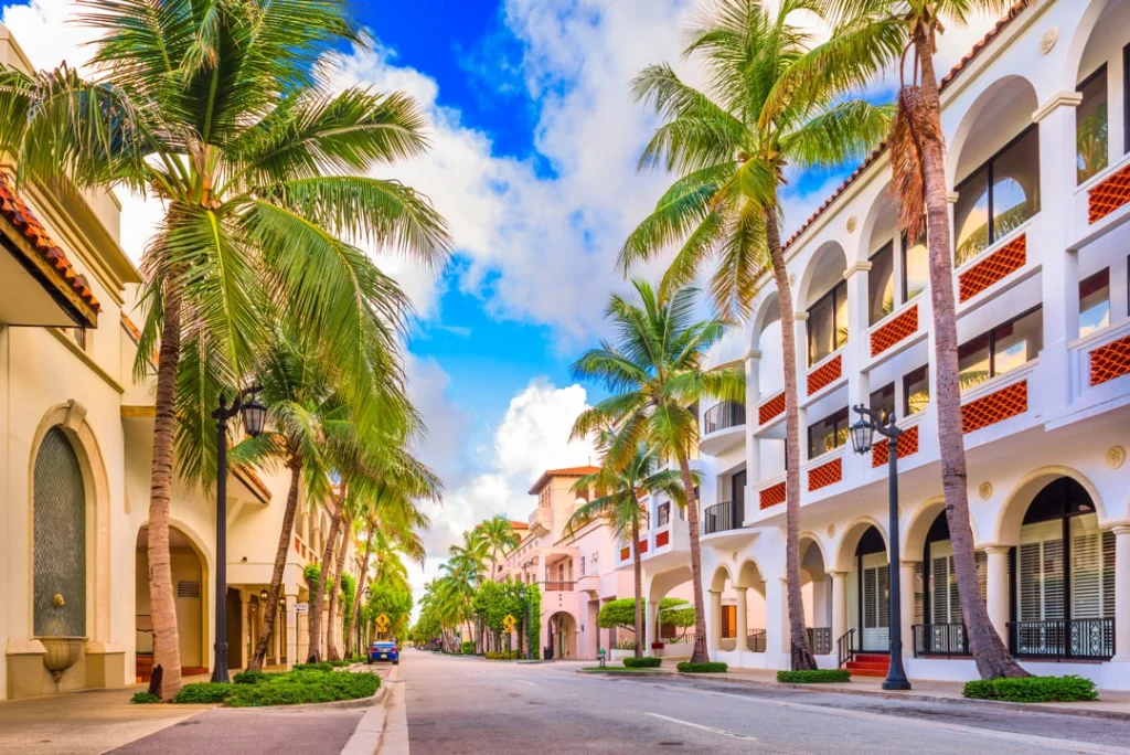 Luxe winkelstraat met boogportieken en hoge palmbomen aan weerszijden van een rustige straat in Palm Beach