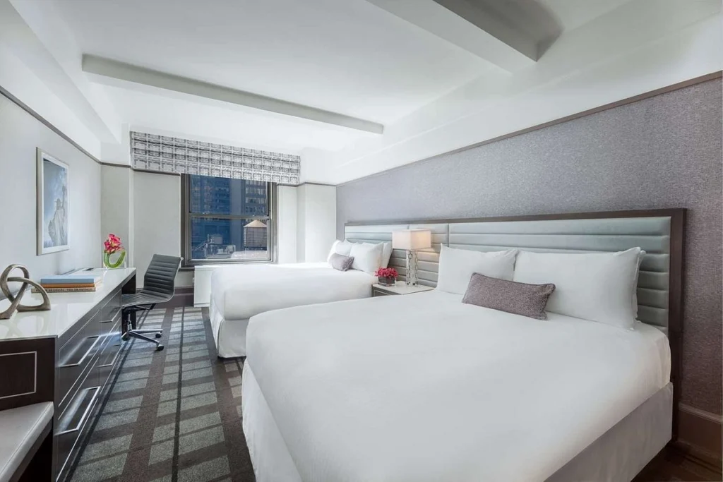 Hotelkamer met twee queensize bedden en uitzicht over de daken van Manhattan in het Park Central Hotel New York, nabij Times Square