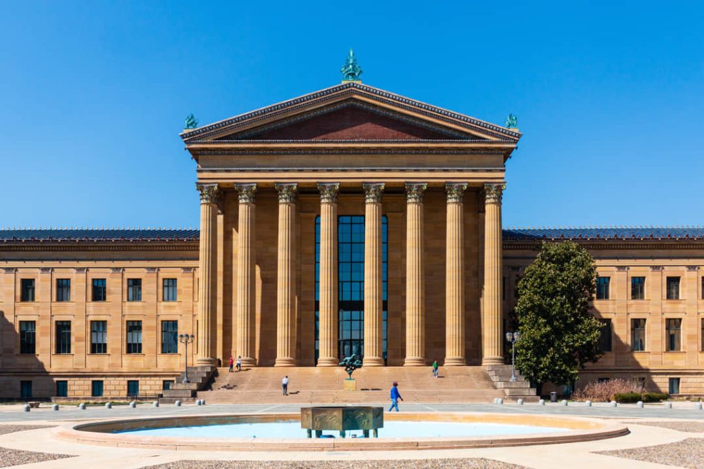 Statige zuilengevel van het Philadelphia Museum of Art met een grote fontein en enkele bezoekers op het plein ervoor