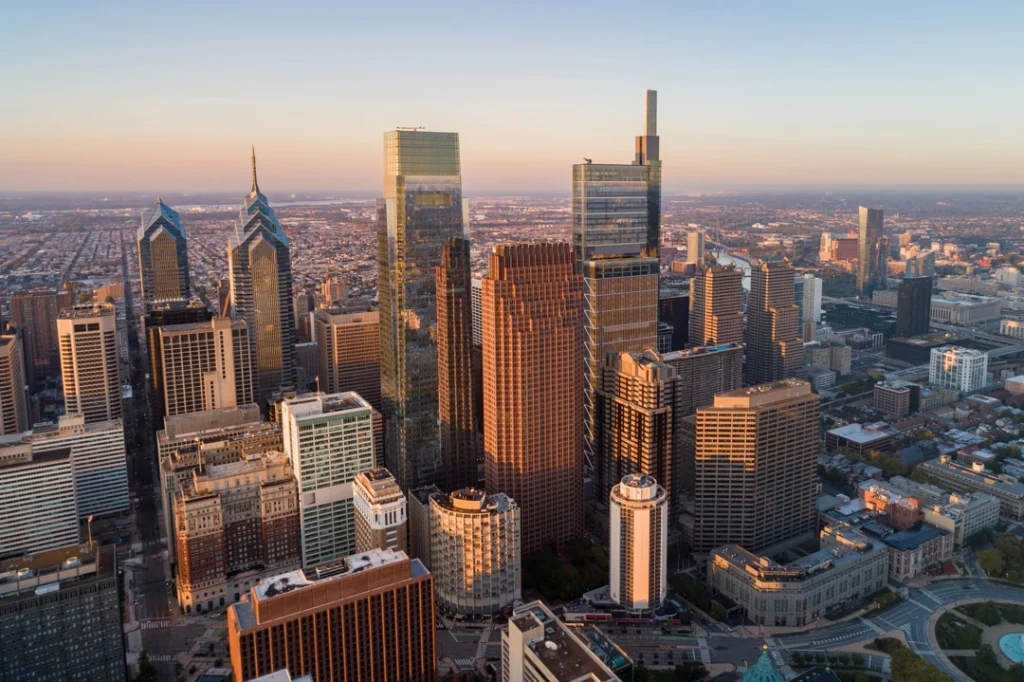 Luchtfoto van de wolkenkrabbers van Philadelphia in warm avondlicht, met de stad die zich uitstrekt tot aan de horizon