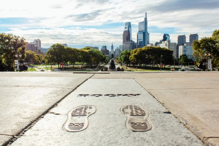 Bronzen voetafdrukken met opschrift Rocky op de beroemde trappen in Philadelphia met de skyline op de achtergrond