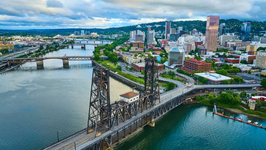 Luchtfoto van de rivier de Willamette met meerdere bruggen waaronder de Steel Bridge en de skyline van Portland
