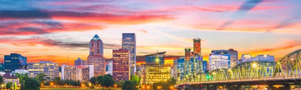 Kleurrijke zonsondergang boven de skyline van Portland met wolkenkrabbers en een verlichte brug over het water