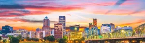 Kleurrijke zonsondergang boven de skyline van Portland met wolkenkrabbers en een verlichte brug over het water
