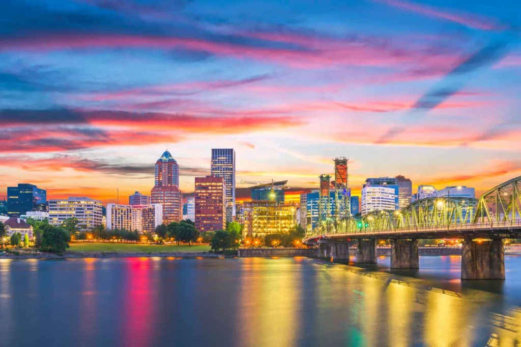 Wolkenkrabbers van Portland tekenen zich af tegen een roze en oranje gekleurde lucht bij zonsopkomst