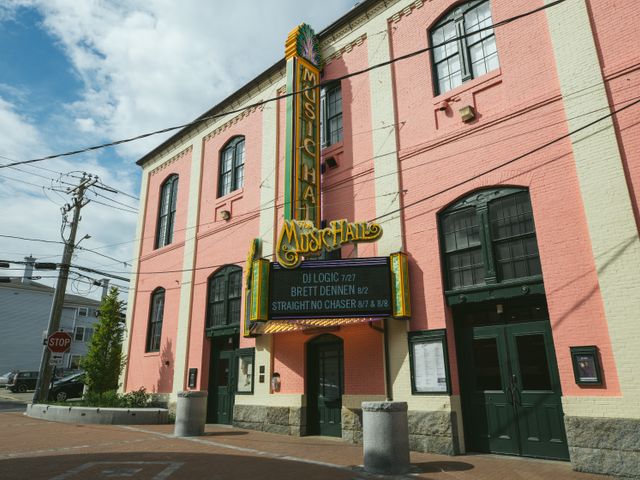 Roze bakstenen theatergebouw met een verticaal lichtreclamebord met de tekst Music Hall op de hoek van een straat in Portsmouth, New Hampshire