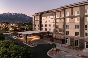 Gevel van een hotel van de keten Courtyard by Marriott bij schemering met bergen op de achtergrond