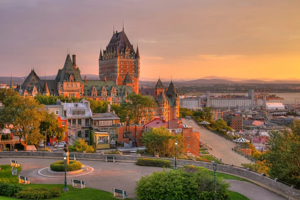 Uitzicht over het plein voor Château Frontenac in Quebec City, met de torenspitsen van het hotel in het licht van de ondergaande zon