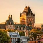Kasteelachtig hotel Château Frontenac met torens en groene daken, boven de daken van de oude stad van Québec