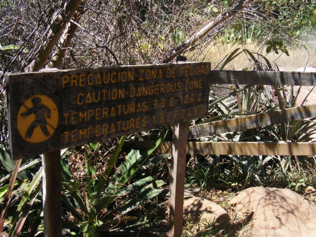 Houten waarschuwingsbord met de tekst caution dangerous zone en temperaturen tot 106 graden bij een pad in Rincón de la Vieja