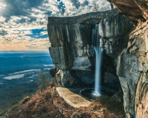 Waterval stort onder een stenen boogbrug in een rotsachtige kloof, met wijds uitzicht over het dal in Rock City