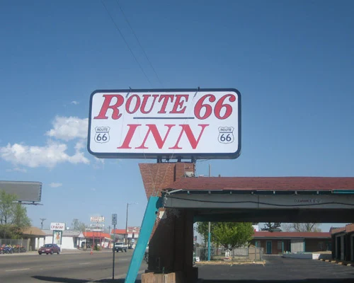 Groot reclamebord met de tekst Route 66 Inn boven een motel met rood dak, langs een straat in het Texas Panhandle