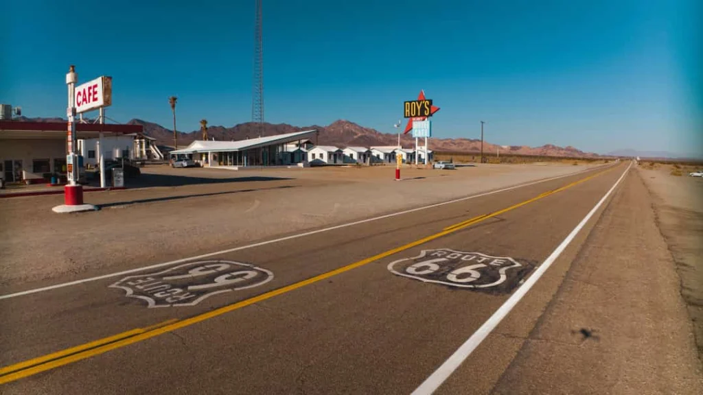 Het beroemde Roy's Cafe en motel langs Route 66 in de woestijn met bergen op de achtergrond