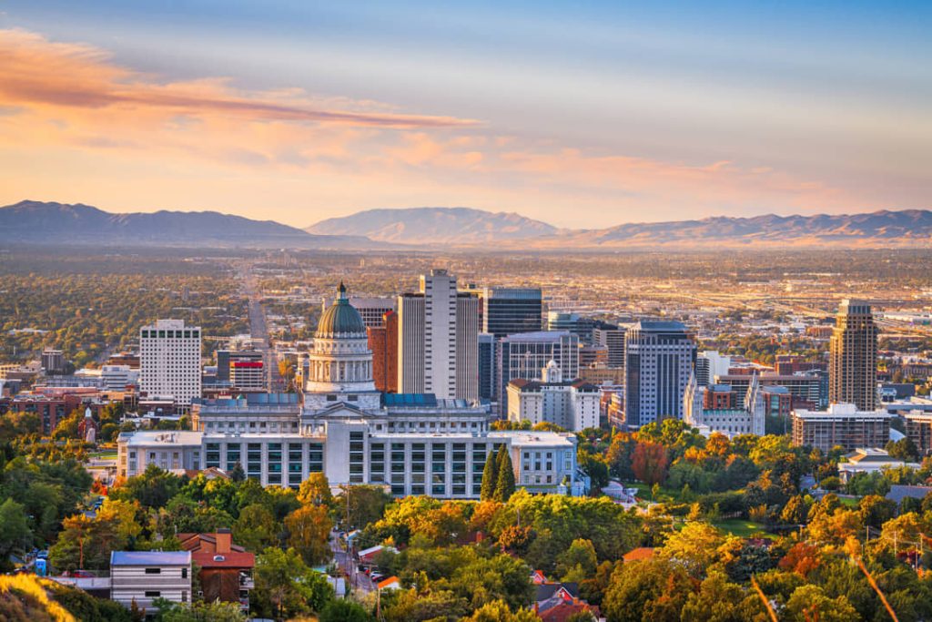 Luchtfoto van het centrum van Salt Lake City met de koepel van het Utah State Capitol op de voorgrond en bergen op de achtergrond bij zonsondergang