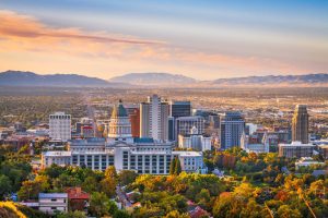 Luchtfoto van het centrum van Salt Lake City met de koepel van het Utah State Capitol op de voorgrond en bergen op de achtergrond bij zonsondergang
