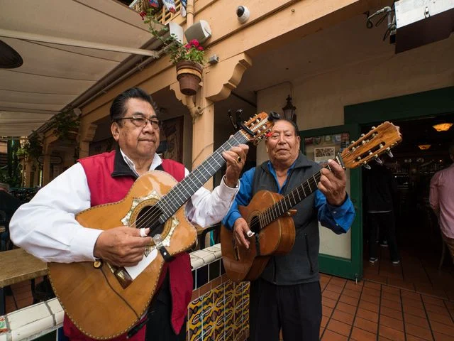 Twee mariachi muzikanten spelen gitaar op een terras bij een restaurant in het historische centrum van San Diego