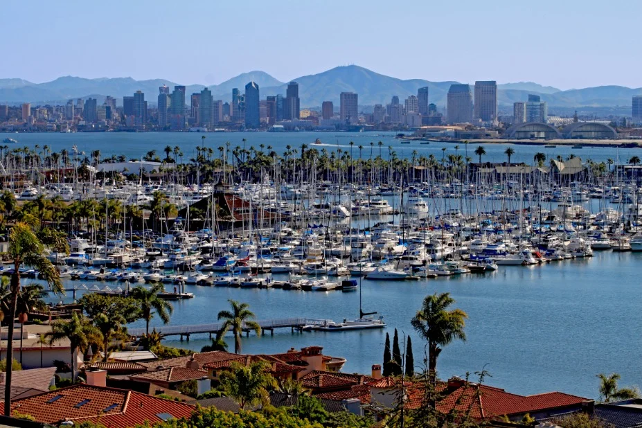 Uitzicht vanaf Point Loma op de skyline van San Diego met een drukke jachthaven vol zeilboten en bergen op de achtergrond