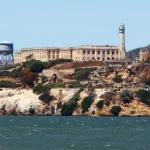 Het voormalige gevangeniseiland Alcatraz met watertoren en gebouwen, gezien vanaf een boot op de baai van San Francisco