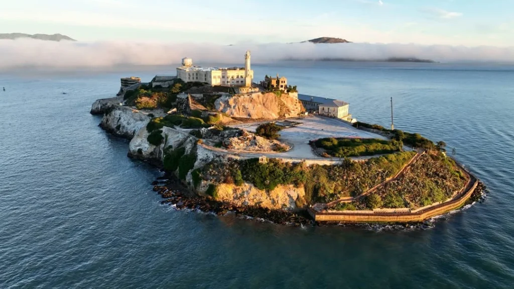 Luchtfoto van Alcatraz eiland met de gebouwen op de rotsen, deels gehuld in mist boven de baai