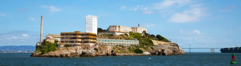 Uitzicht vanaf het water op Alcatraz Island met de voormalige gevangenisgebouwen en vuurtoren in San Francisco