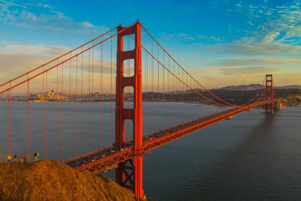 De rode Golden Gate Bridge steekt uit boven de heuvels bij een kleurrijke zonsondergang in San Francisco