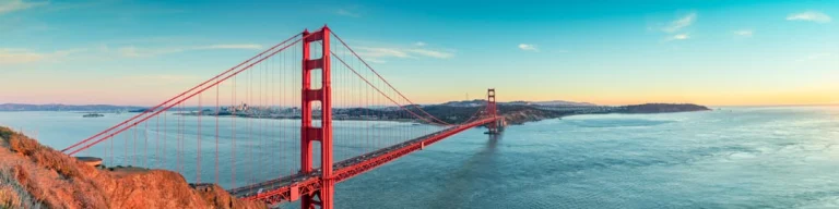 Panoramisch uitzicht op de rode Golden Gate Bridge in San Francisco met de baai en heuvels op de achtergrond bij zonsondergang