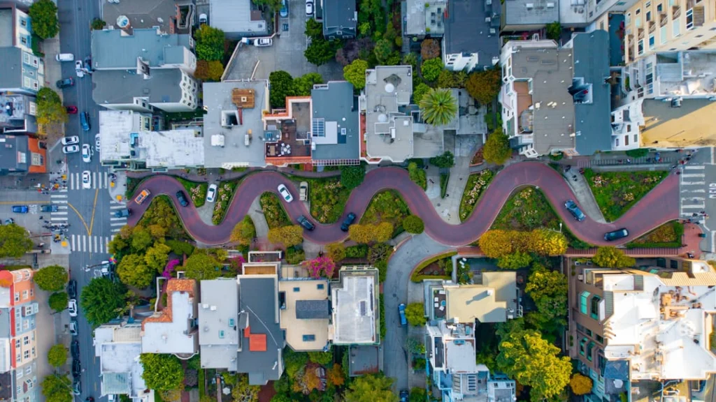 Luchtfoto van de bochtige straat Lombard Street met bloemen en huizen tussen de haarspeldbochten