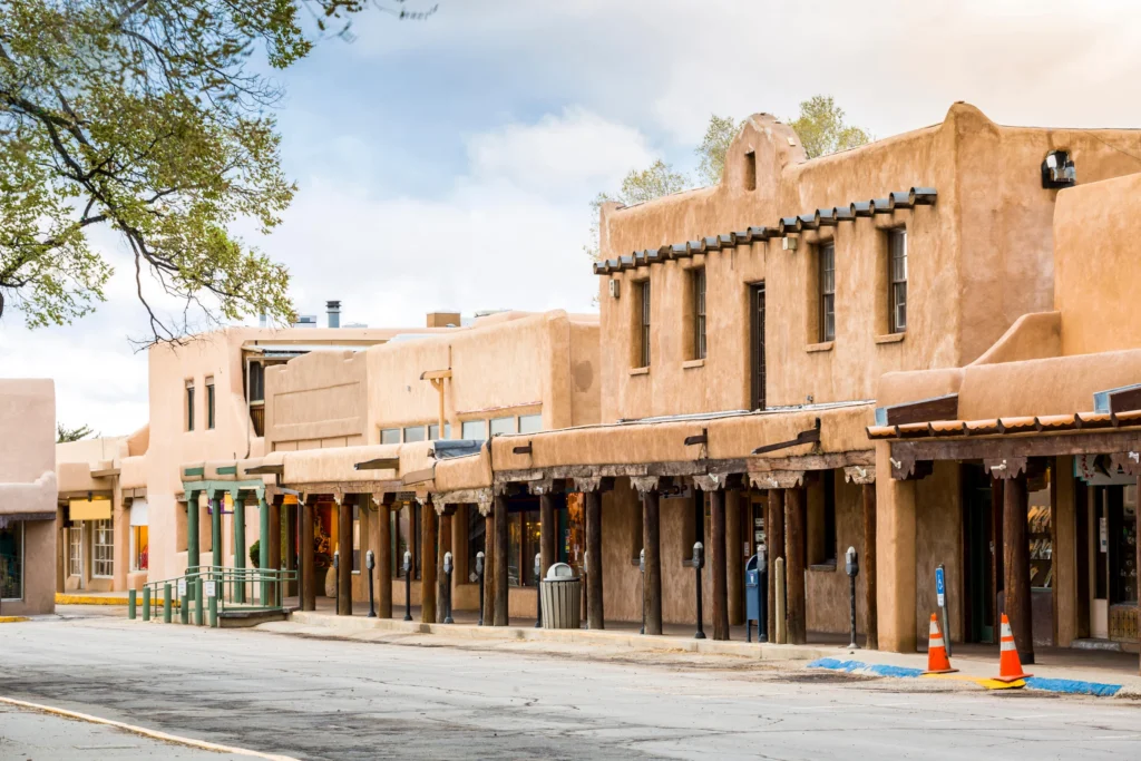 Traditionele adobe gebouwen met houten pilaren en luifels langs een straat in het centrum van Santa Fe