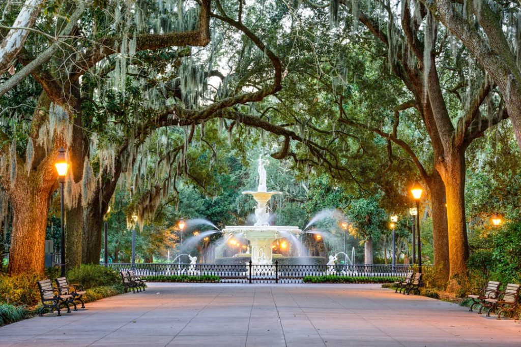 Witte sierfontein aan het einde van een pad, omringd door oude eikenbomen met hangend Spaans mos in Forsyth Park in Savannah in Georgia