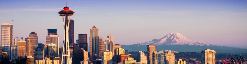 Skyline van Seattle met wolkenkrabbers en de Space Needle op de voorgrond en de besneeuwde top van Mount Rainier aan de horizon