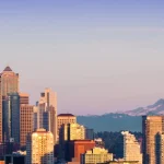 Skyline van Seattle met wolkenkrabbers en de Space Needle op de voorgrond en de besneeuwde top van Mount Rainier aan de horizon