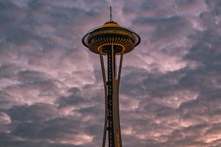 De Space Needle in Seattle torent op tegen een roze en paarse bewolkte avondlucht bij zonsondergang