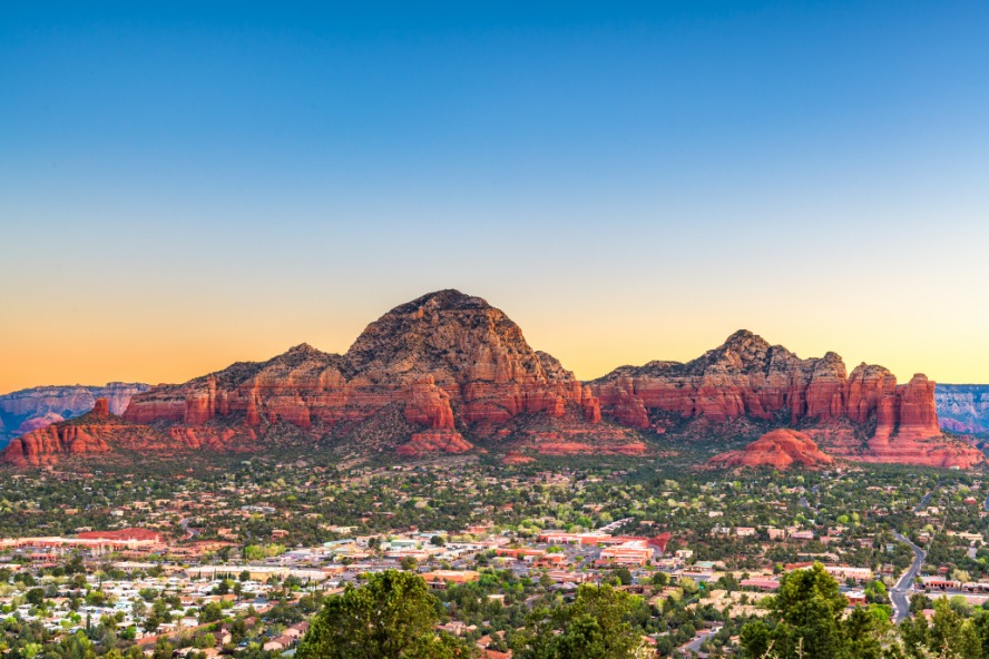 Uitzicht bij zonsondergang over Sedona in Arizona met rode rotsformaties boven het stadje in het dal