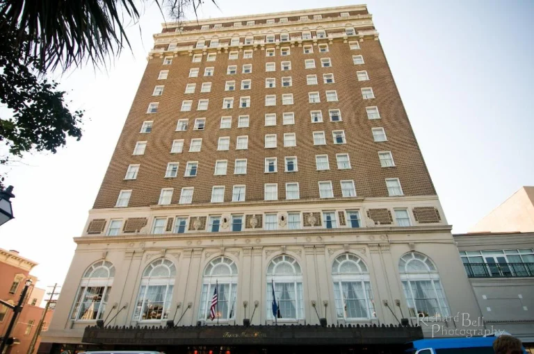 Een hoog hotelgebouw met bruine bakstenen gevel en witte sierlijsten, gefotografeerd vanaf de straat in South Carolina