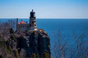 Vuurtoren Split Rock Lighthouse op een steile rotsachtige klif hoog boven het blauwe water van Lake Superior