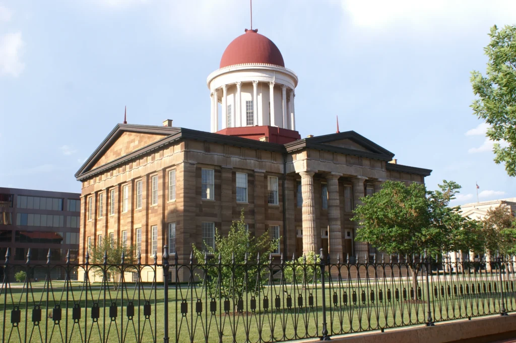 Historisch gebouw met zuilen en een rode koepel, omgeven door een smeedijzeren hek, het Old State Capitol in Springfield in Illinois