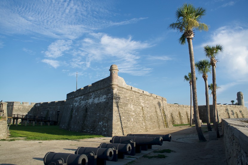 Stenen fort met kanonnen op het gazon en palmbomen ernaast in het historische St. Augustine in Florida