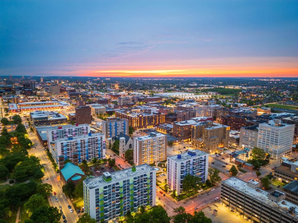 Uitgestrekte luchtfoto van woonwijken en flatgebouwen in St. Louis met een gekleurde lucht bij het ondergaan van de zon