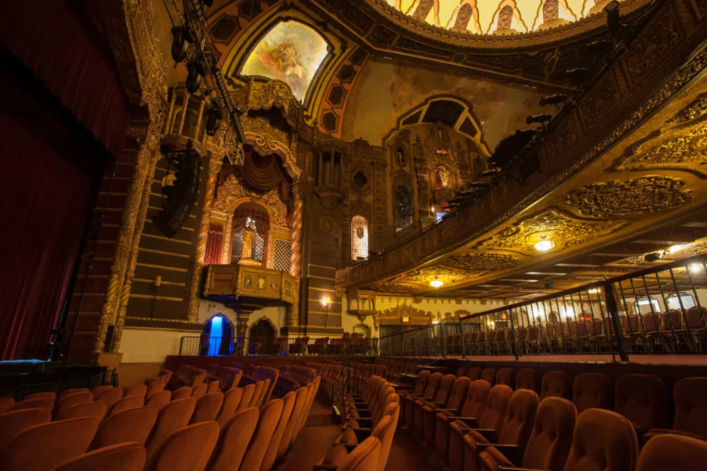 Uitzicht op de versierde koepel en het balkon van de theaterzaal in het St. George Theatre met rode fluwelen stoelen