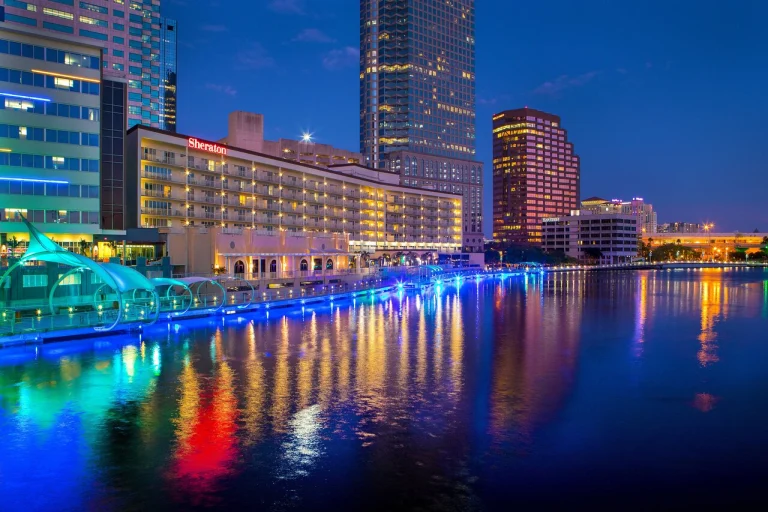 Verlichte wolkenkrabbers en het Sheraton hotel in Tampa weerspiegelen in het rustige rivierwater tijdens de schemering