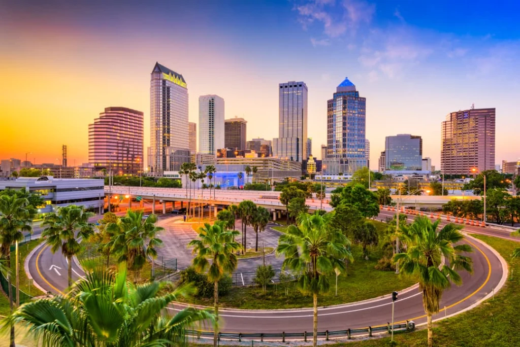 Zonsondergang boven de skyline van Tampa in Florida met wolkenkrabbers, snelwegen en palmbomen op de voorgrond